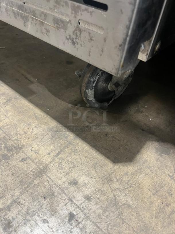 Imperial commercial stainless steel double stacked convection oven, natural gas, on casters, visible wear on wheels.