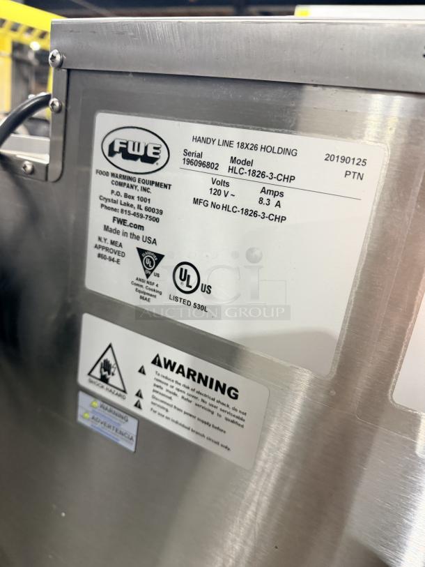 FWE Handy Line HLC-1826-3-CHP 3-Pan Heated Holding Cabinet, stainless steel, model 196096802, 120V, UL listed, warning labels visible.