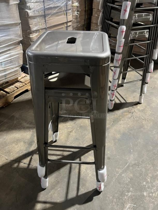 Brand new commercial gray gunmetal backless bar-height stool, stackable, industrial style, protective covers on feet.