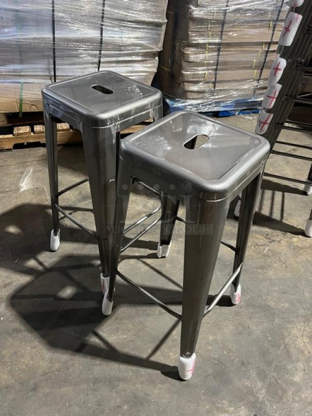 Brand new gray gunmetal bar-height stools, backless, industrial style, stackable, commercial-grade, protective caps.