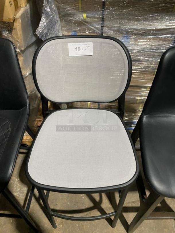 Brand new commercial bar-height dining chair with a modern style, black metal frame, and light gray upholstered seat and back.
