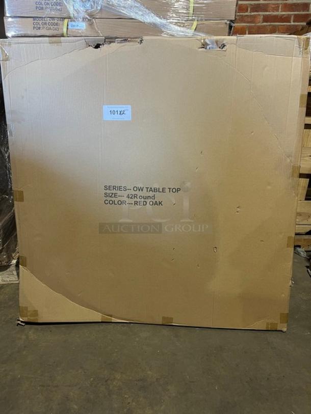 Brand new commercial 42" round red oak dining table, textured finish. Packaging labeled with size and color. With regular height base.