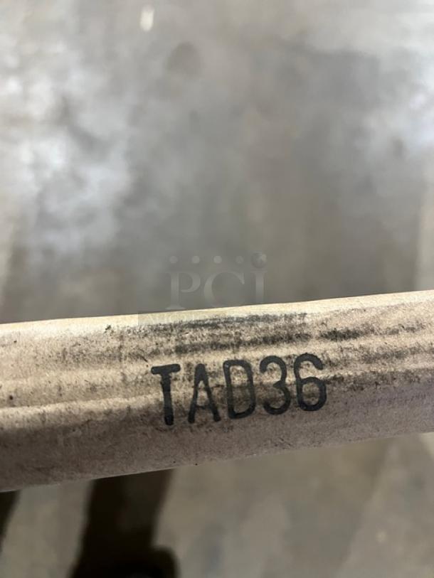 Brand new TAD36 commercial aluminum dining table; matte steel hairpin legs; indoor/outdoor use; model marking visible.