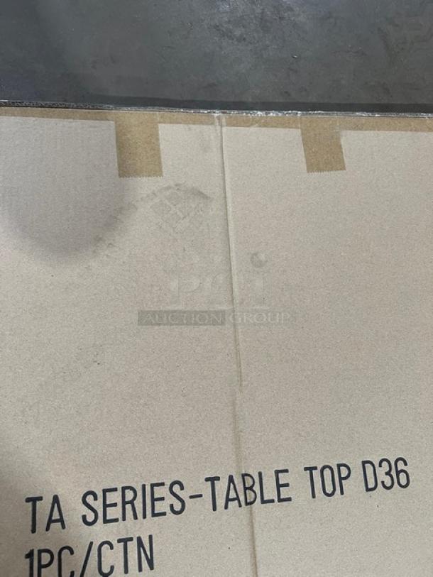 New commercial aluminum round cocktail/dining table, model TAD36, matte steel hairpin legs, in original packaging.