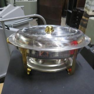 Oval stainless steel chafer with gold accents, featuring a domed lid and sturdy base. Ideal for catering or buffet use.