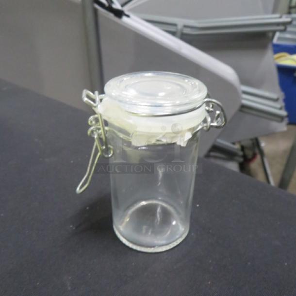New mini glass spice jar with hinged lid, model 6XBID, in excellent condition. Clear glass with secure clasp.