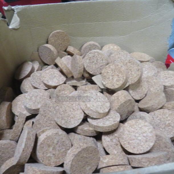 A box filled with new 2-inch cork lids, round, uniform size, clean and unused, suitable for jars or containers.