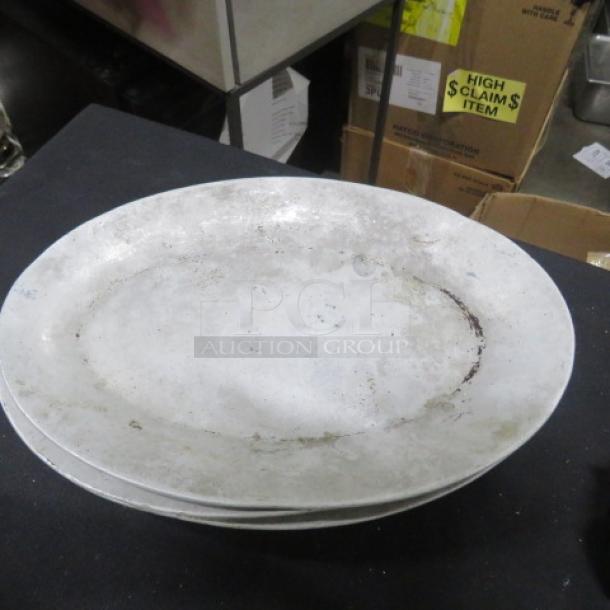 10.5x7-inch aluminum platter, showing wear. Stack of similar plates. "High Claim $ Item" boxes in background.