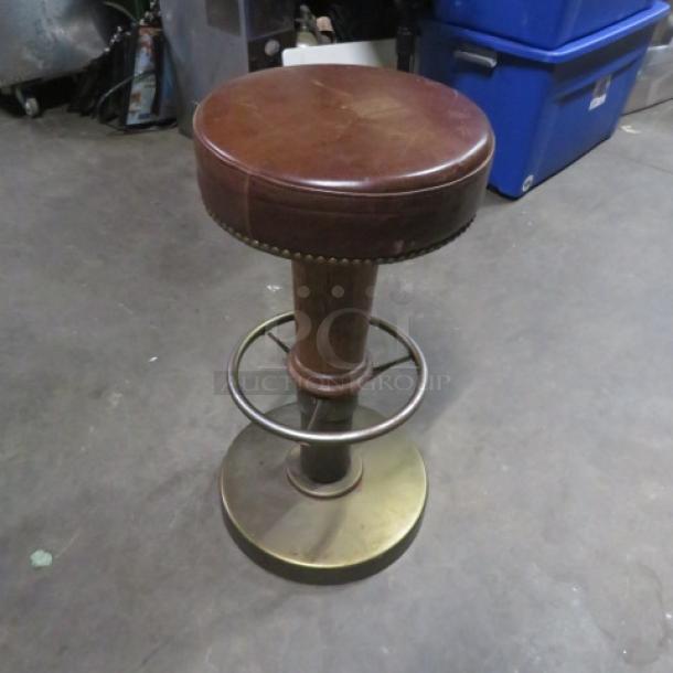 Metal and wooden barstool with brown leather cushioned seat, nail head trim, and footrest. Good condition.