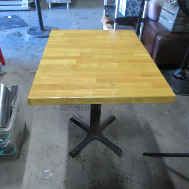 Solid wooden butcher block table on pedestal base, 24x30x30 inches, excellent condition.