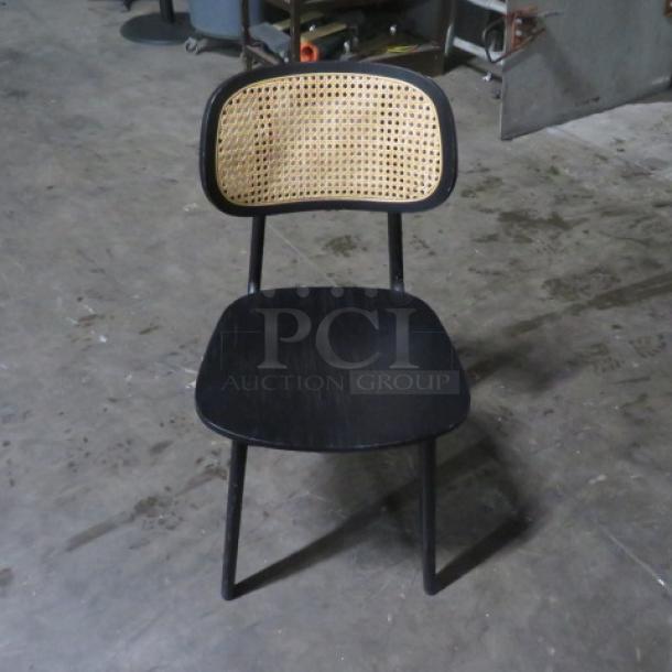 Black wooden chair with cane backrest, sturdy build, minimal wear. Simple modern design, 2XBID model.