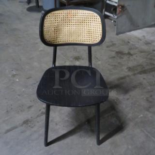 Black wooden chair with a woven rattan backrest, model 2XBID. Features a simple, elegant design. Good condition.
