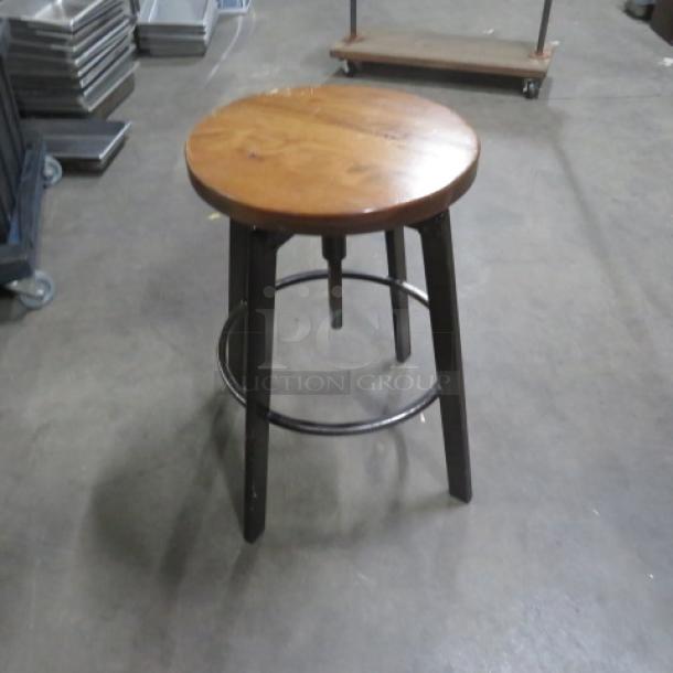 Black metal and wooden adjustable bar stool, circular wooden seat, sturdy metal legs, footrest, used condition.