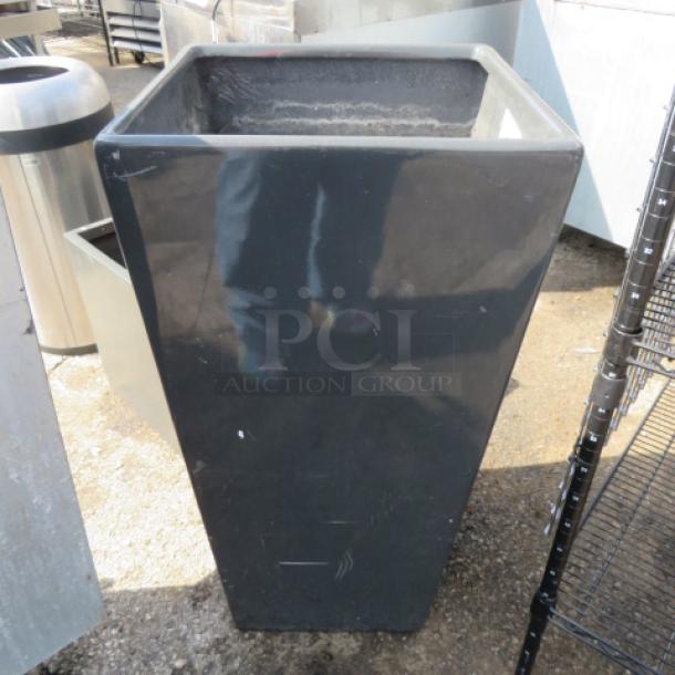 Tall black planter, 18.5x18.5x36 inches, glossy finish, minor surface scuffs, suitable for outdoor use.