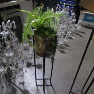 Metal planter with lush green plant on tall stand. Features a metal pot and cascading foliage. Excellent condition.