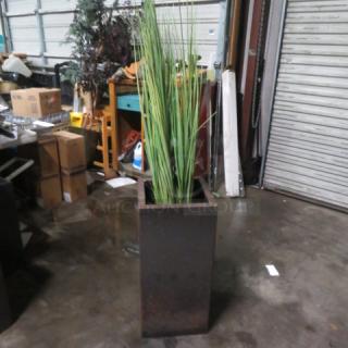 Tall square metal planter with decorative grass. Measures 14x14x29 inches. Slightly weathered condition.