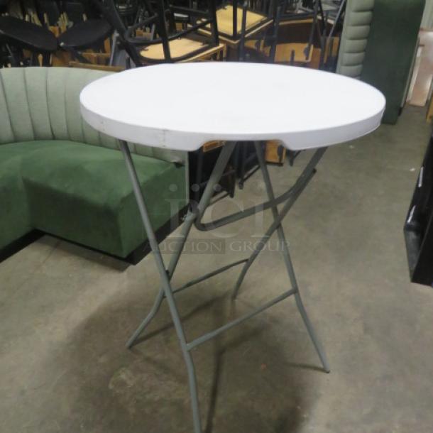 Cosco folding round bar height table, 31x43 inches, white top, metal legs, minor wear, ideal for events.