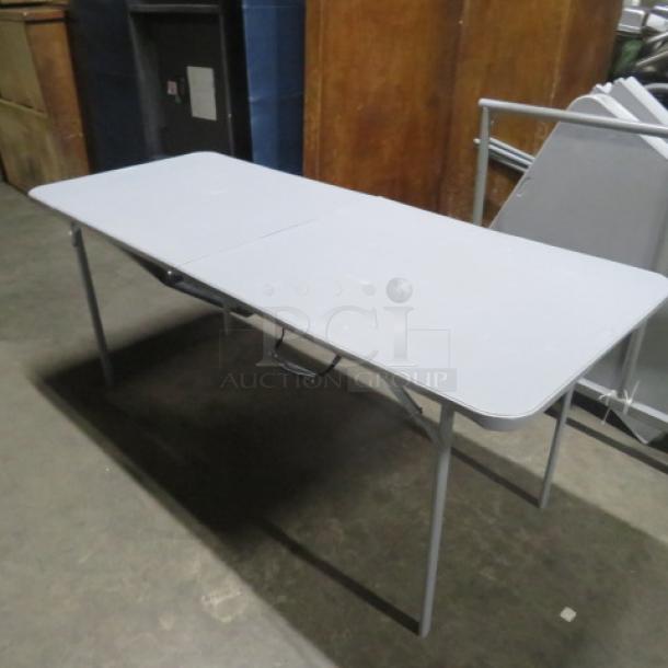 Cosco folding table, 72x29x30 inches, gray, plastic top, metal legs, foldable for easy storage, in good condition.