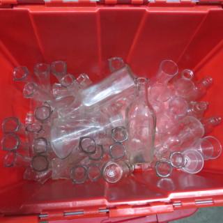 Assorted glass tabletop vases and bottles, various shapes and sizes, in a red container. Good condition.