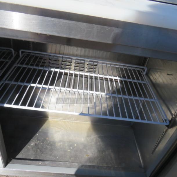 Avantco 2-door refrigerated prep table interior with wire shelving, stainless steel, Model 178SSPT60-HC, in good condition.