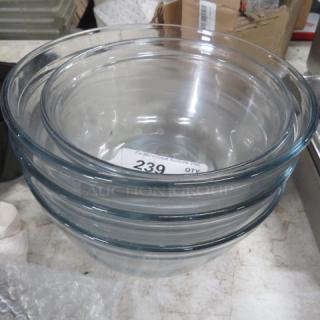 Assorted glass mixing bowls, set of four, clear glass, stackable design, good condition, auction tag with number 239 visible.