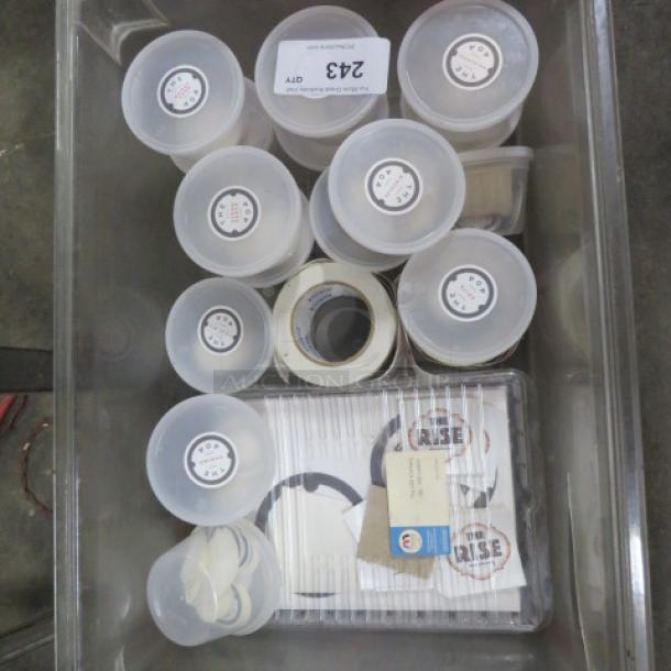 Box of assorted items including labeled containers, rolls of stickers, and miscellaneous papers, suitable for various uses.