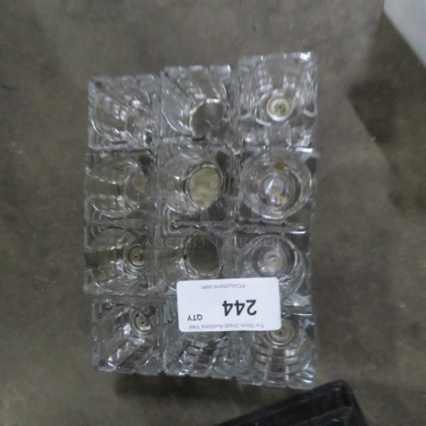 Heavy cut glass candle holder, 12 pieces. Clear glass, square shape, pristine condition, stacked for display.