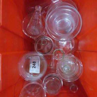 Set of assorted glassware in a red bin, including beakers and flasks. Visible tag marked "248." Items appear in good condition.