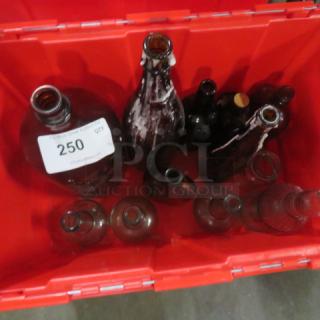 A collection of assorted vintage bottles in a red container. Condition varies; includes a large numbered bottle labeled "250".