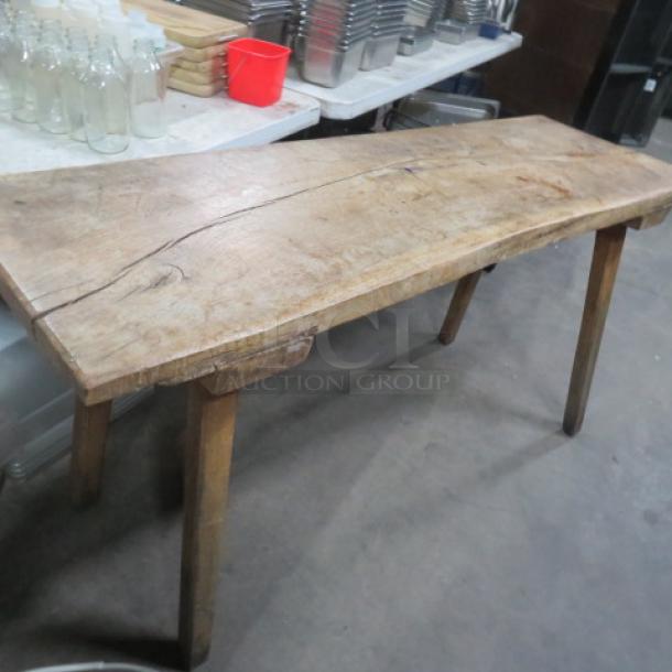 Unique wooden table with slab wood top, wooden legs; dimensions 66.5x22x33 inches. Rustic finish, visible grain and knots.