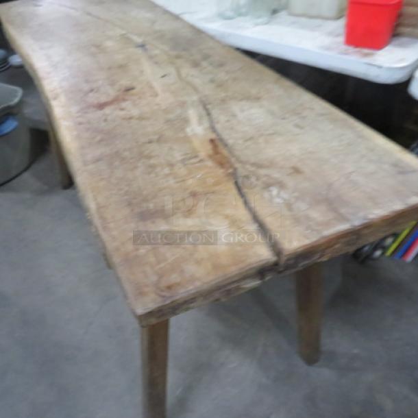 Unique table with slab wood top, wooden legs. Measures 66.5" x 22" x 33". Rustic finish, visible natural wood textures.