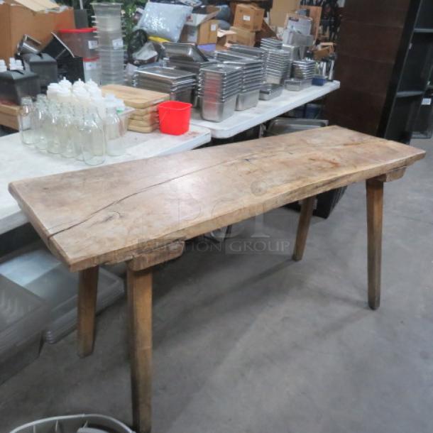 Unique table with slab wood top and wooden legs, measuring 66.5x22x33 inches. Rustic condition with visible grain.