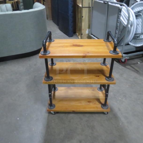 Industrial wooden cart with 3 shelves, 27.5x16x35 inches, on casters. Black metal supports, used condition.