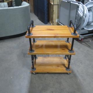 Industrial wooden cart with 3 shelves, 27.5x16x35 inches, on casters. Black metal supports, used condition.