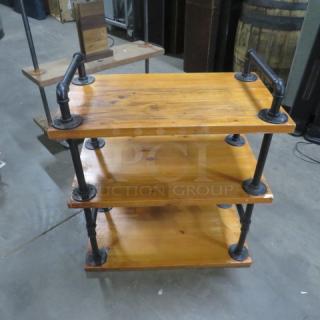 Industrial wooden shelving unit with 3 shelves, measuring 27.5"x16"x31". Features pipe-style metal supports, good condition.