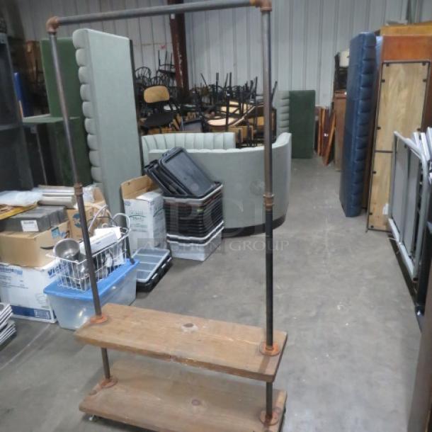 Industrial-style wooden shelving unit with two shelves, over hanger, and casters. Dimensions: 36x15x68.5 inches.