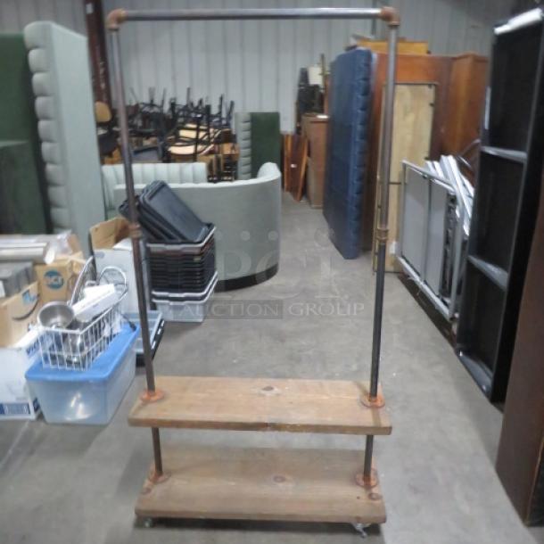 Industrial-style wooden shelving unit on casters, featuring two shelves and an overhead hanger. Dimensions: 36x15x68.5 inches.