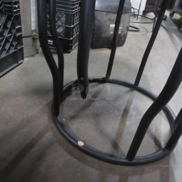 Round table with black metal top, wooden base; measures 21.5x16 inches. Distinctive curved legs. Good condition.