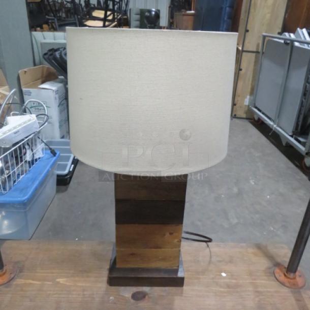 Wooden lamp with a fabric shade, rectangular base, natural finish, excellent condition. Ideal for home decor.