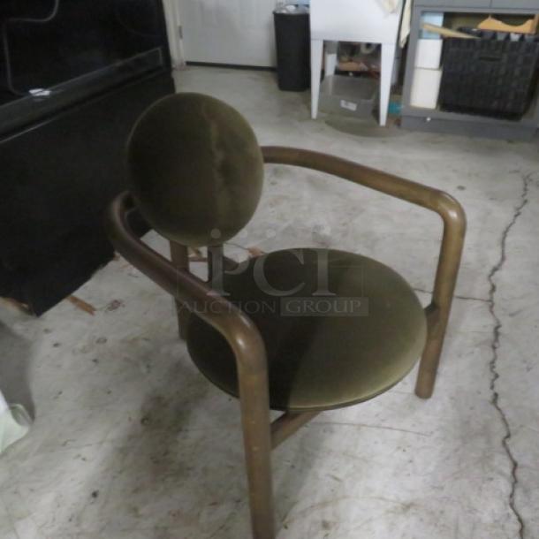 Wooden armchair with brown velvet cushioned seat and back, rounded frame design, excellent condition.