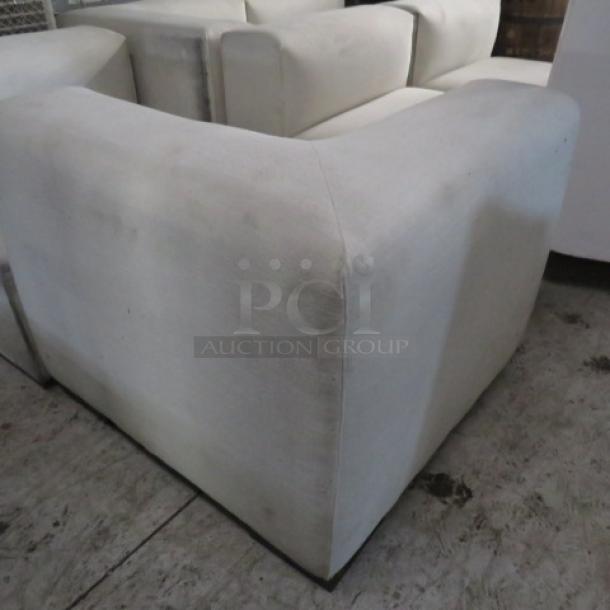 White overstuffed 6-piece sectional couch, large sections, slightly worn, suitable for spacious living areas.
