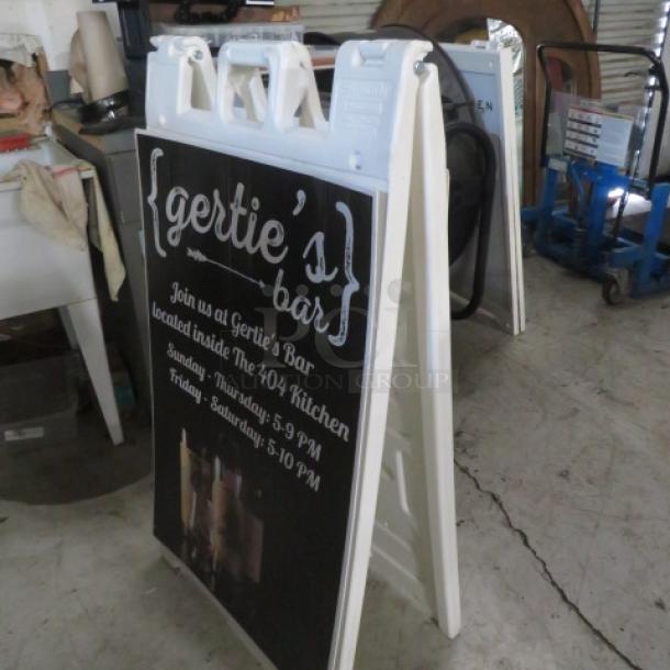 Sidewalk sign, 24x45 inches, featuring "Gertie's Bar" text. White frame, durable condition, promotional information visible.