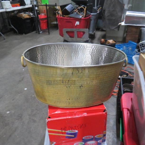 Hammered metal beverage tub, round with brass-like finish, good condition, side handles, visible hammered texture.