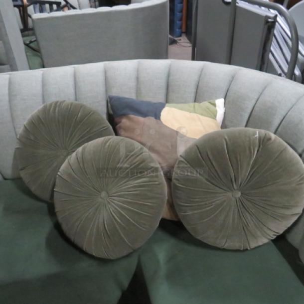 Assorted pillows, including three round tufted green velvet pillows and one multicolored square pillow. Excellent condition.