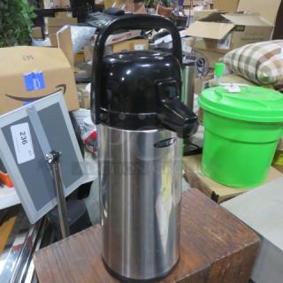 Stainless steel airpot with black lid and pump, Bestek branding visible, used condition, back-handle for easy carrying.