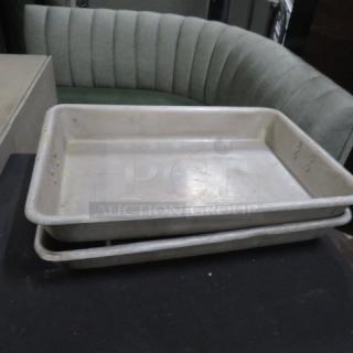 Stacked aluminum roaster pans, durable, lightly used condition, suitable for large meal preparations.