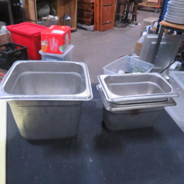 Assorted stainless steel hotel pans in varying sizes, used condition, suitable for commercial kitchen applications.