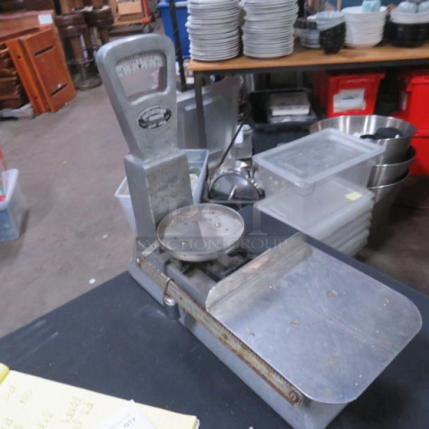 Vintage baker's scale, metal construction, round weigh plate, dial with markings, rustic condition, industrial aesthetic.