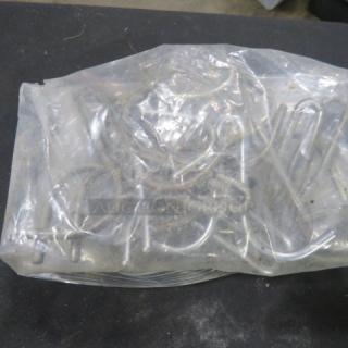 Clear plastic bag containing a lot of metal pot hooks. Hooks appear new, unopened, and various in shape and size.