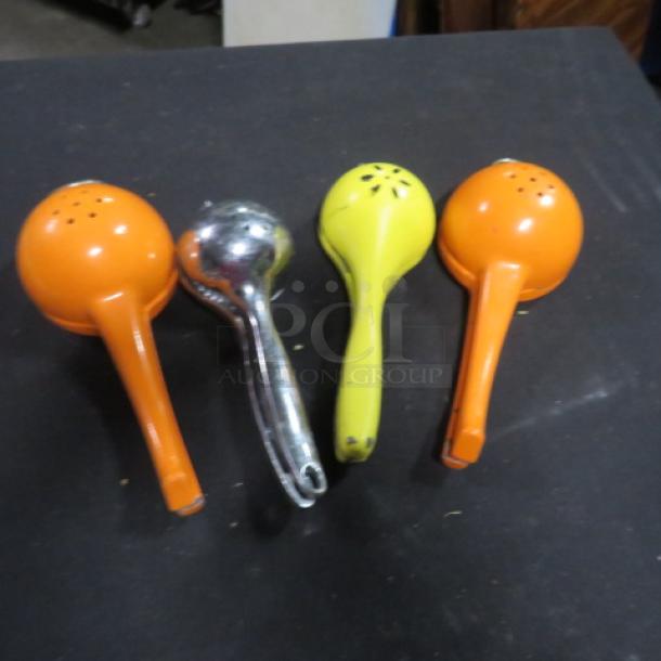 Four citrus presses, three orange and one green, and one silver. Used condition with minor wear. Item 4XBID.